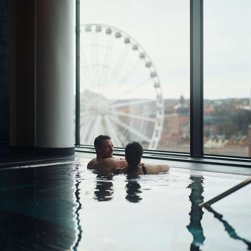 Ett par i poolen på Upper house Spa med utsikt över Liseberg