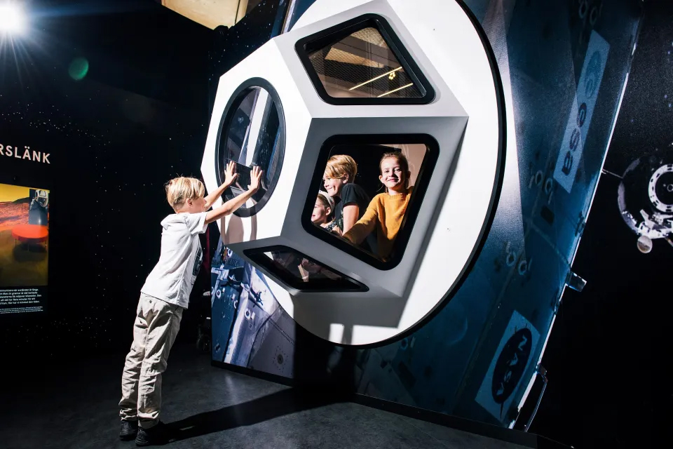 Barn utforskar en rymdkapsel i Universeums utställning Rymdresan.