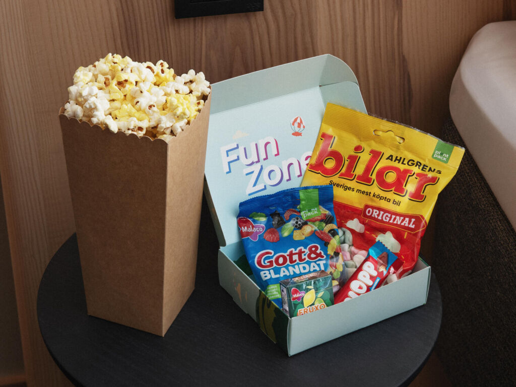 Funbox med popcorn och snacks i färgglad förpackning.