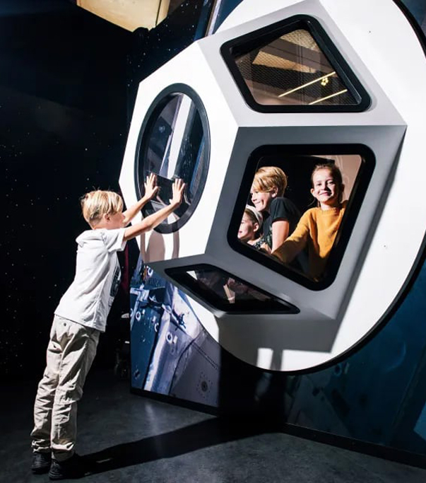 Barn utforskar en rymdkapsel i Universeums utställning Rymdresan.