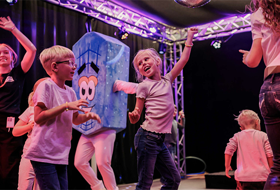 Children dancing with a mascot during an activity at Gothia Towers